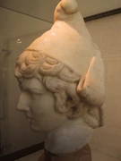 Testa marmorea di Attis con il caratteristico berretto frigio, scultura di epoca romana.