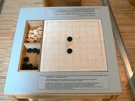 Ricostruzione museale del ludus latrunculorum, il gioco da tavolo dei soldati romani, con scacchiera e pedine.